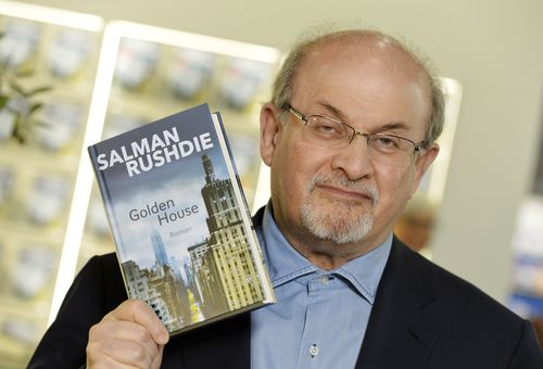 Author Salman Rushdie, shows a new book as he visits the book fair in Frankfurt, Germany, Thursday, Oct. 12, 2017.