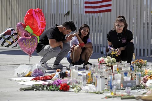 Roberto Lopez, from left, Briana Calderon and Cynthia Olvera, of Las Vegas, pause at a memorial site. (AAP)