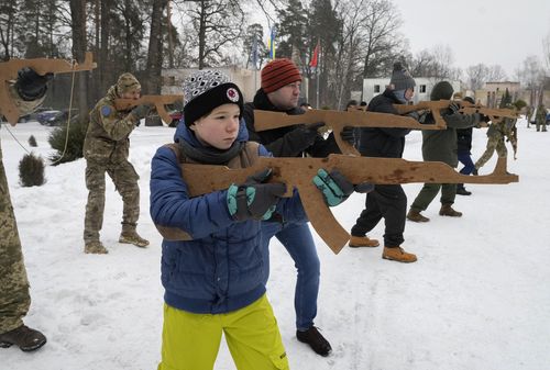 Yuri, 12, trains with members of Ukraine's Territorial Defense Forces, volunteer military units of the Armed Forces, close to Kyiv, Ukraine, Saturday, Feb. 5, 2022. Hundreds of civilians have been joining Ukraine's army reserves in recent weeks amid fears about a Russian invasion. (AP Photo/Efrem Lukatsky)