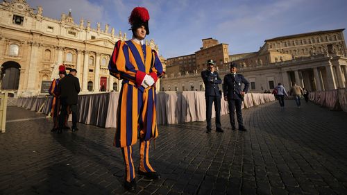 Pontifical Swiss guards stand in St. Peter's Square before the arrival of the body of Pope Francis, who will lie in state at St. Peter's Basilica for three days, at the Vatican, Wednesday, April 23, 2025. (AP Photo/Andreea Alexandru)