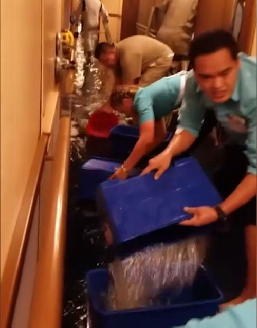 Crew members are seen removing water after a water line break floods a Carnival cruise ship. (Supplied)