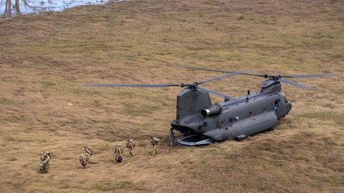 Australian Army soldiers from 7th Brigade step off a CH-47F Chinook helicopter to assist with flood relief efforts.