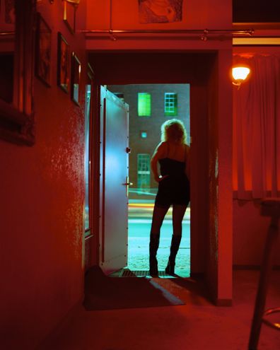 Prostitute Standing in Nightclub Doorway Looking Out