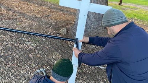 Mr Abdallah and another man rebuilding the memorial for the four children lost in the Oatlands crash.