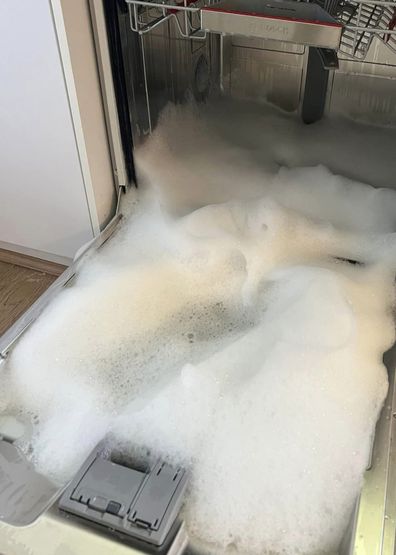 A woman's dishwasher overflowed with detergent foam after using washing up liquid in it.