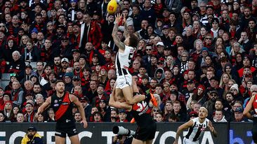 Jamie Elliott of the Magpies takes a spectacular mark over Ben McKay of the Bombers during the annual Anzac Day clash.