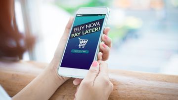 Stock BNPL Buy now pay later online shopping concept. Hands holding mobile phone