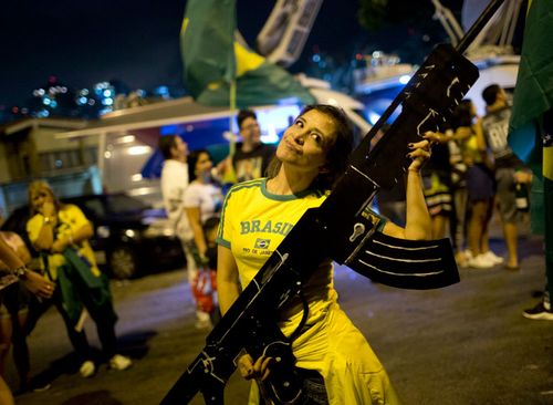 This Bolsonaro supporter holds a huge imitation assault rifle after his victory. Loosening gun controls was a major policy of the far-right candidate.