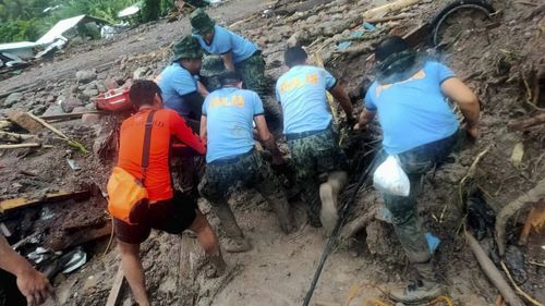 Rescuers retrieve bodies during the search and rescue operations due to landslides caused by Tropical Storm Nalgae in Barangay Kushong, Datu Odin Sinsuat, Maguindanao province, southern Philippines on Friday Oct. 28, 2022.