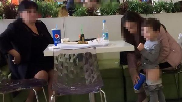 Live stream: little boy's mum holds cup for him to pee into in crowded restaurant.