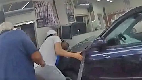 Police and bystanders rush to the aid of a baby stuck under a car.