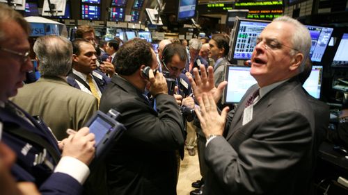 Traders, specialists and floor officials gather around the trading post where Lehman Brothers stock is traded on the floor of the New York Stock Exchange in 2008. (AAP)