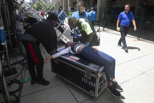 A woman is treated by a paramedic after being pulled from the crowd (Chris Young/The Canadian Press via AP)