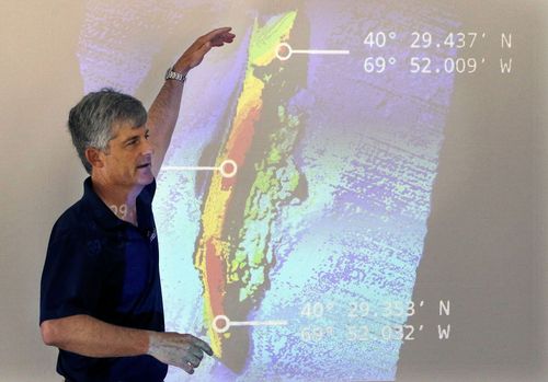 OceanGate CEO and co-founder Stockton Rush speaks in front of a projected image of the wreckage of the ocean liner SS Andrea Doria during a presentation on their findings after an undersea exploration, on June 13, 2016, in Boston.