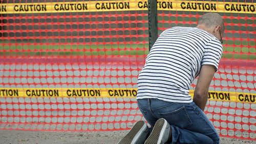 A protester kneels outside the Nebraska State Penitentiary as Moore is executed inside.