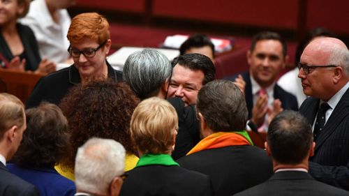 Penny Wong and Dean Smith embrace after the bill was passed 43-12. (AAP)