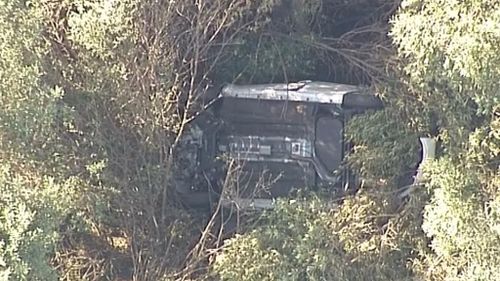 Woman found dead inside upturned car in Sydney bushland after passer-by spots wreckage