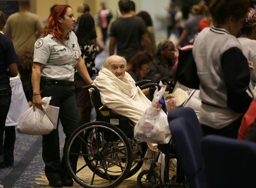 Evacuee Teddy Gifford, 90, waits for a medical evaluation with first responder Veronica Garza at the Lakewood Church in Houston.