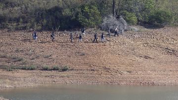 A police search team work on the shore of the Arade dam near Silves, Portugal, Wednesday May 24, 2023.  
