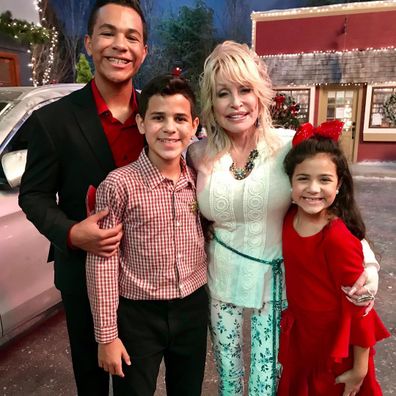 Dolly Parton with her Christmas on the Square co-stars Tristan, Tyson and Tahlia Hill.
