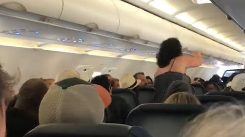 Two male passengers intervene in what appears to be an attempt to calm the woman – to no avail. Picture: Facebook/Chianti Washington