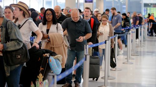 Os viajantes aéreos enfrentam longas filas e tempos de espera de duas horas no ponto de verificação de segurança da TSA no Terminal E do Aeroporto Intercontinental George Bush.