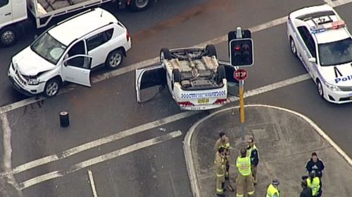 Police car rolls at intersection in Hoxton Park in Sydney's west
