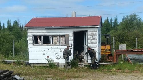 Police search empty buildings in the hunt for the suspects. 