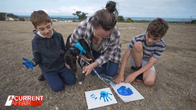 Artie the dog making art with his adopted family.