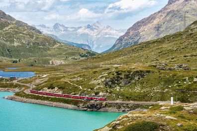 Bernina Express train at the White Lake in Ospizio Bernina, upper Engadin, Graubuenden, Grisons, Switzerland.