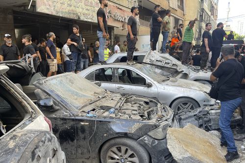 People gather at the scene of an Israeli missile strike in the southern suburbs of Beirut, Friday, Sept. 20, 2024 