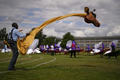 A member of the Mahogany carnival group with a giraffe costume takes part in a rehearsal for their upcoming performance at the Platinum Jubilee Pageant, at Queens Park Community School, in north London, Saturday, May 28, 2022.  