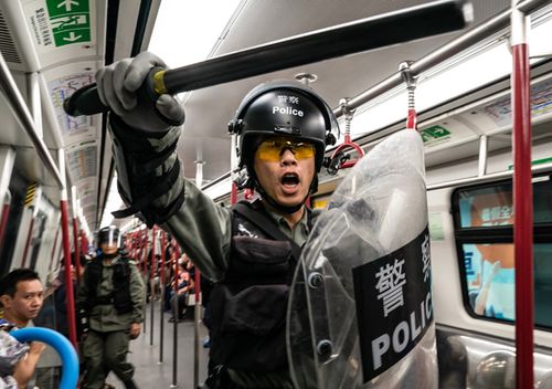 Riot police charge in a train at the Tung Chung MTR station after protesters block the transport routes to the Hong Kong International Airport on September 1, 2019 in Hong Kong, China.