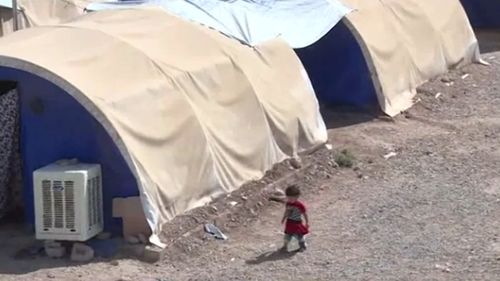 A young girl wanders through the displaced persons camp, with officials telling reporters women and children will likely be extradited to their home nation without charge. (RT)
