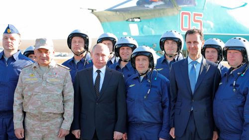 Russian Defence Minister Sergei Shoigu, 2nd left, President Vladimir Putin, 4th left, and Syrian President Bashar Assad, 3rd right, pose for a photo with Russian military pilots. (AP)