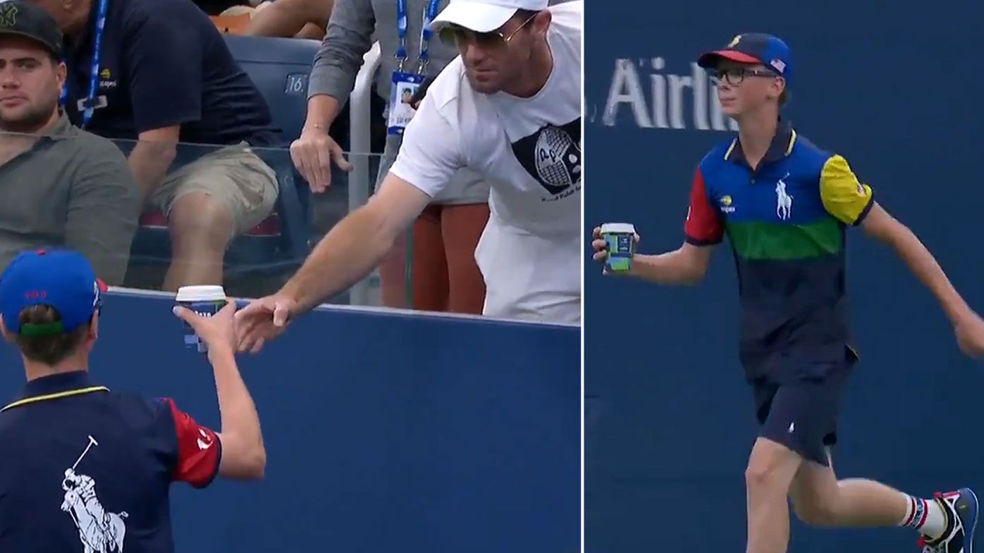 Venus Williams' coach hands a coffee to a ball boy to deliver to the tennis star
