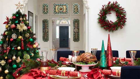 Christmas set up with Christmas tree and wreath, table with Christmas crackers and roast ham