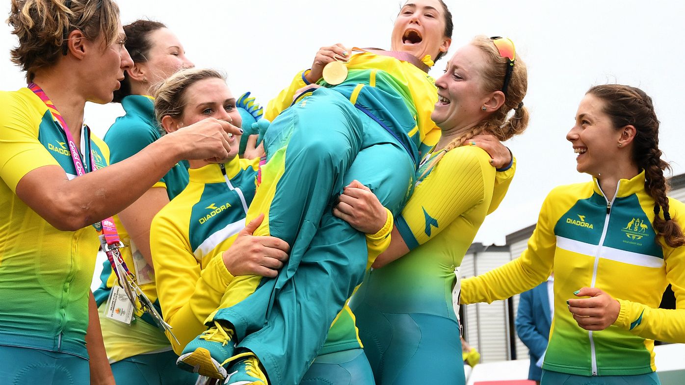 Chloe Hosking of Australia (centre) is lifted by her teammates as she celebrates her gold medal in the women's cycling road race on day ten of the XXI Commonwealth Games on the Gold Coast, Australia, Saturday, April 14, 2018. 