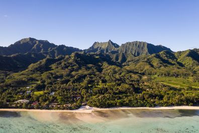 The idyllic Rarotonga island, part of the Cook islands, in the Pacific ocean, with its jungle covered mountain and stunning beach.