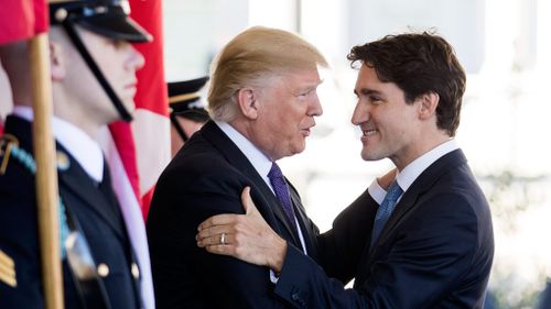 President Donald Trump and Canadian Prime Minister Justin Trudeau embrace at the White House. (AAP)