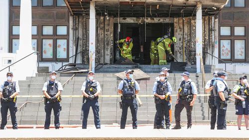 Firefighters respond at the fire-damaged entrance to the Old Parliament House following a protest.