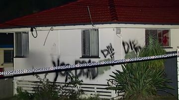 Graffiti can be seen on the burned Woodridge home. (9NEWS)