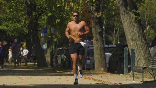 Si vedono persone godersi il clima caldo intorno ai TAM di Melbourne domenica 13 aprile 2025. 