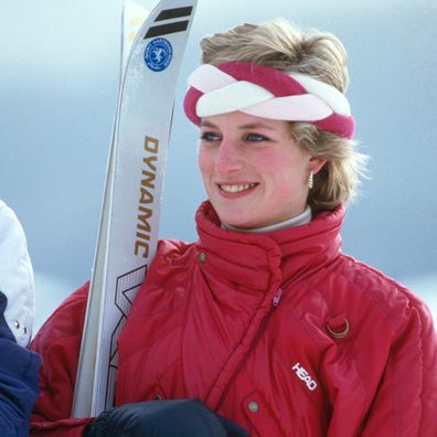 KLOSTERS, SWITZERLAND - FEBRUARY 06: Diana, Princess of Wales, wearing a red ski suit by Head and a braided headband, holds her skis and poles during a holiday in Klosters on February 6, 1986 in Klosters, Switzerland. (Photo by Anwar Hussein/Getty Images)