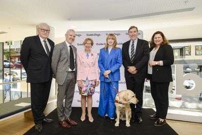 Ingrid Barnes with her guide dog Banner speaking at a Guide Dogs event.