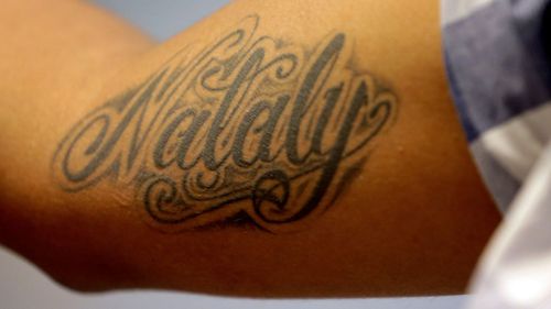Wilson Romero shows his tattoo of his five-year-old daughter Nataly's name at the Annunciation House. (AP)