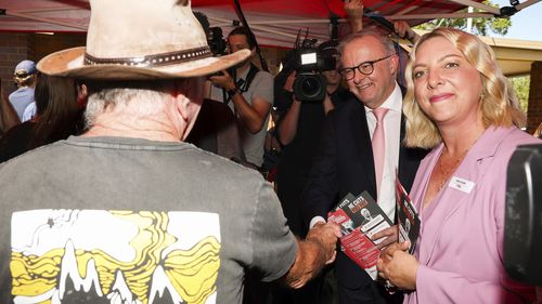 Prime Minister Anthony Albanese with Labor candidate for Bonner, Kara Cook, and a baby during a visit to a an early voting polling place, in the electorate of Bonner, in Wynnum