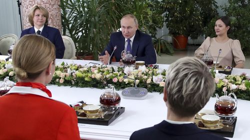 Russian President Vladimir Putin, centre, speaks to representatives of the flight crew of Russian airlines as he visits to Aeroflot Aviation School outside Moscow, Russia, Saturday, March 5, 2022 