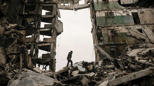 Un rezident își caută bunurile într-un bloc de apartamente distrus în timpul luptei dintre forțele ucrainene și ruse de la Borodinka.