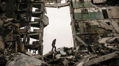 A resident looks for belongings in an apartment building destroyed during fighting between Ukrainian and Russian forces in Borodyanka.